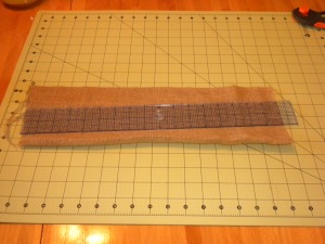 Cutting each strip of burlap to weave across the chair seat.